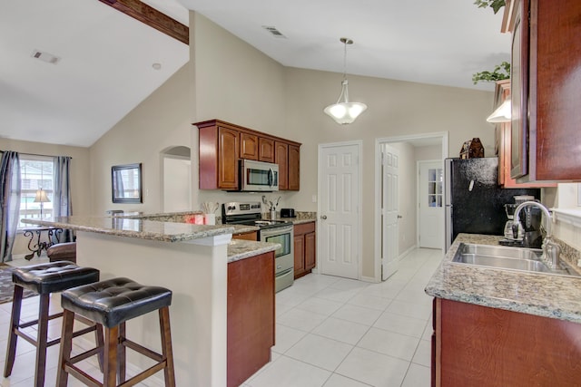 kitchen with a kitchen bar, appliances with stainless steel finishes, sink, light stone counters, and kitchen peninsula