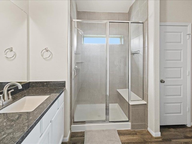 bathroom with vanity, wood finished floors, and a shower stall