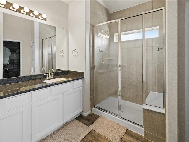 full bathroom featuring vanity, a shower stall, and wood finished floors