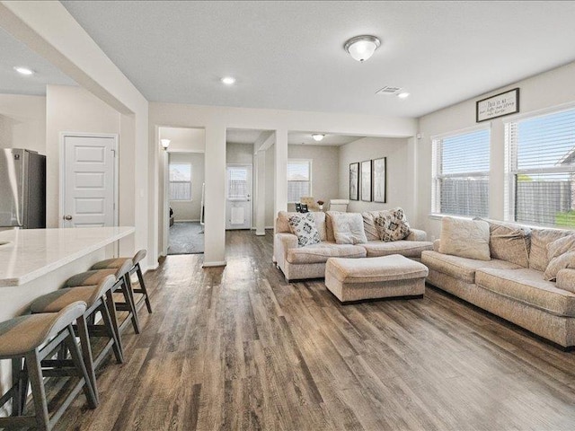 living area featuring recessed lighting, dark wood-style floors, and a wealth of natural light
