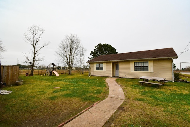 ranch-style home featuring a playground and a front yard