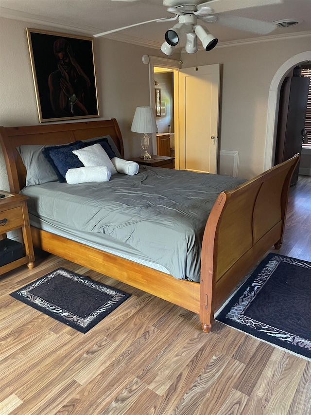 748 Queens Ct, Port Arthur, TX 77642 - bedroom featuring crown molding, arched walkways, and wood finished floors