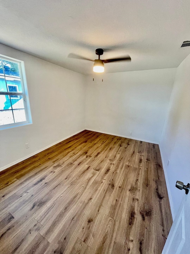 empty room with a textured ceiling and light wood-type flooring