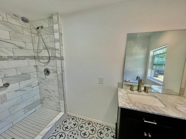 bathroom featuring a tile shower, vanity, and tile patterned floors