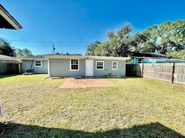 rear view of property featuring a lawn, a patio, and central AC