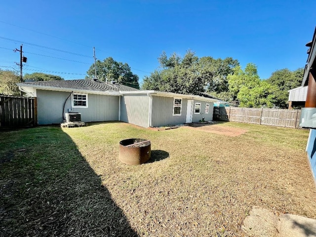 back of property featuring cooling unit and a yard