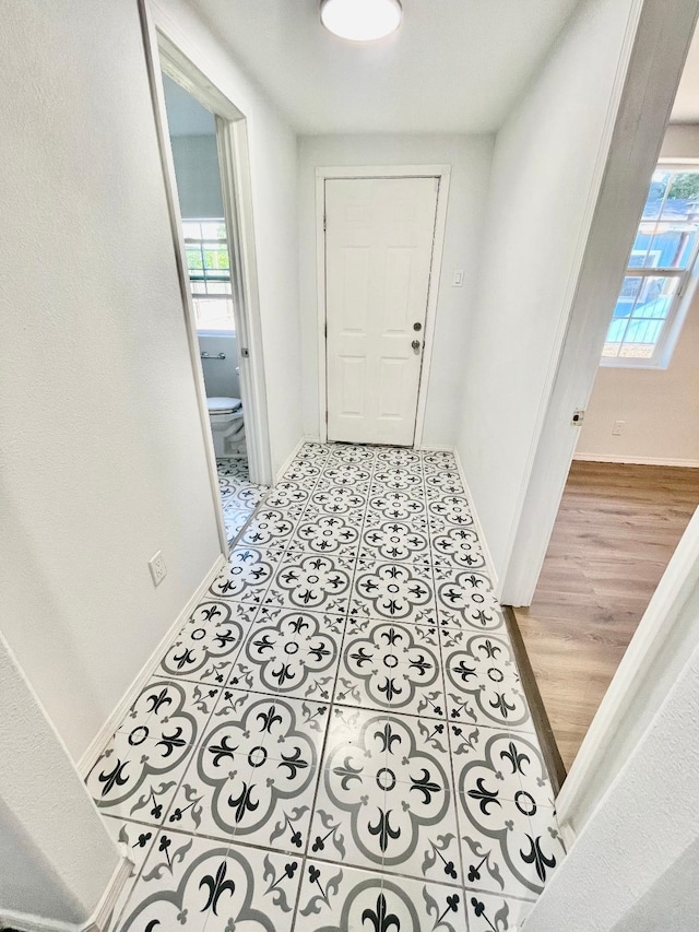 corridor with light tile patterned floors and a healthy amount of sunlight