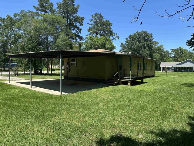2922 Little Cypress Dr, Orange, TX 77632 - back of property with an attached carport and a yard