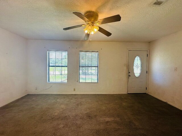 2922 Little Cypress Dr, Orange, TX 77632 - entryway with dark carpet, a textured ceiling, a ceiling fan, and baseboards