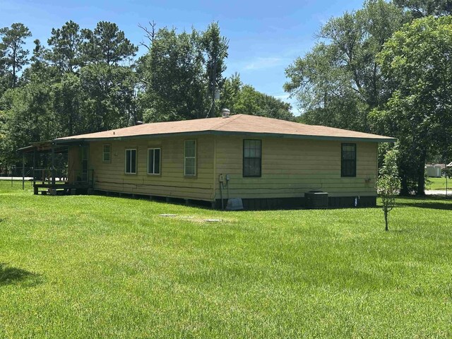 2922 Little Cypress Dr, Orange, TX 77632 - view of side of property with a yard and central AC unit