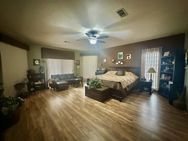 bedroom featuring ceiling fan, a textured ceiling, and hardwood / wood-style flooring