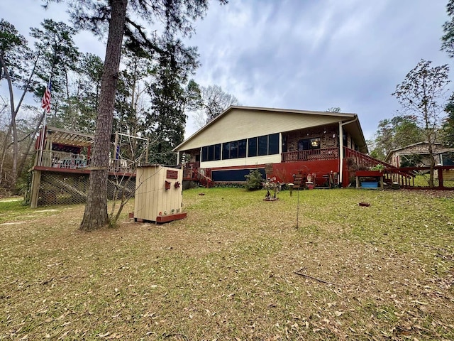 rear view of house with a deck and a lawn