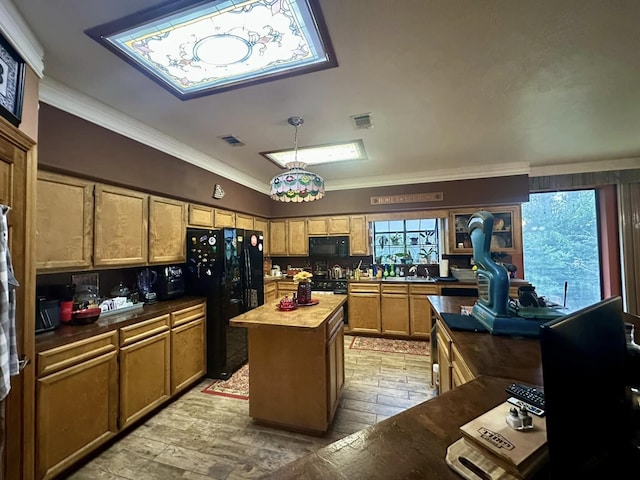 kitchen with black appliances, a wealth of natural light, wood counters, and a kitchen island