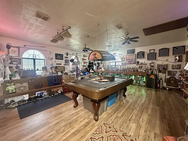 recreation room with ceiling fan, wood-type flooring, billiards, and a textured ceiling