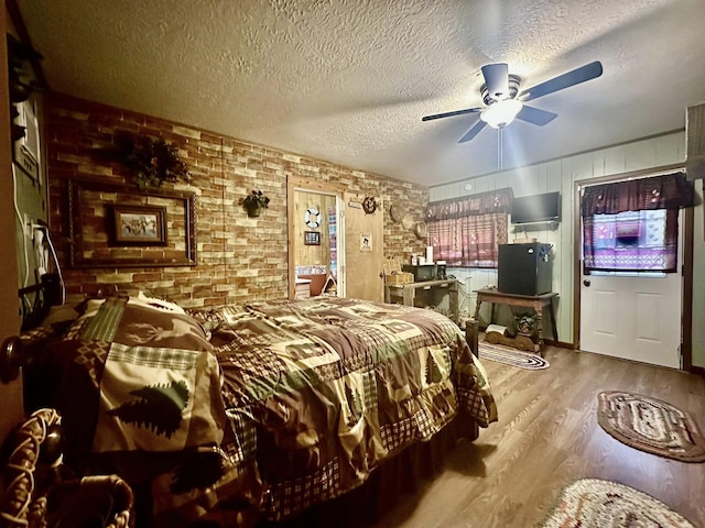 bedroom with a textured ceiling, ceiling fan, and hardwood / wood-style flooring