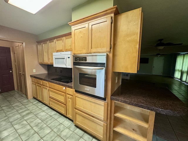 kitchen with black electric cooktop, ceiling fan, stainless steel oven, and light brown cabinets