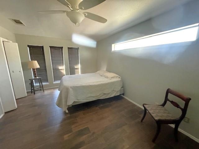 bedroom with ceiling fan, dark wood-type flooring, and lofted ceiling