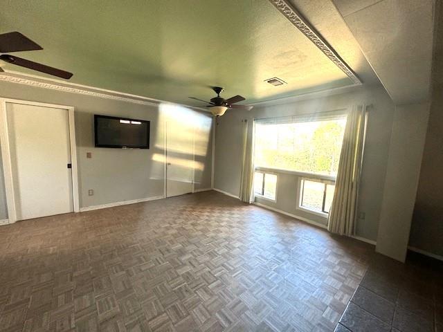 empty room featuring ceiling fan and dark parquet floors