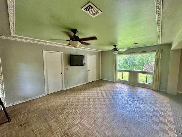 interior space featuring ceiling fan, a textured ceiling, and light parquet floors