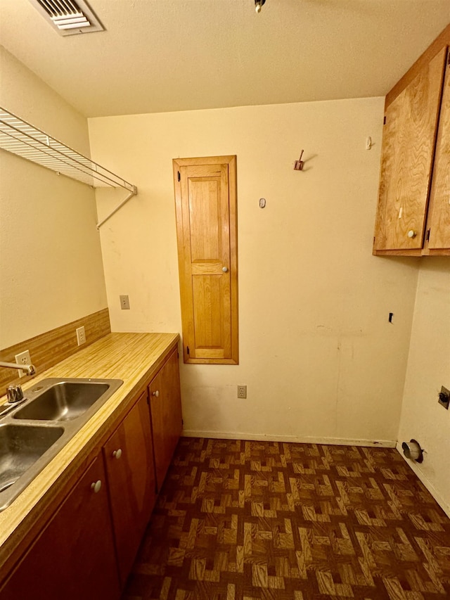 laundry room featuring dark parquet flooring and sink