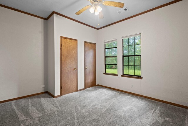 10425 Bussey Rd, Silsbee, TX 77656 - unfurnished bedroom with carpet, crown molding, multiple closets, and ceiling fan