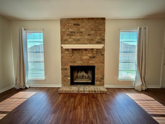 unfurnished living room featuring dark hardwood / wood-style flooring and plenty of natural light