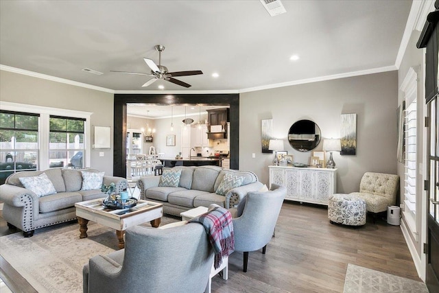 living room with ceiling fan, sink, wood-type flooring, and ornamental molding