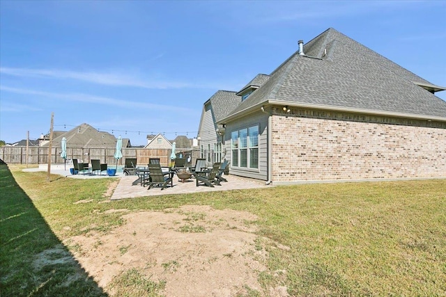 rear view of property featuring a patio area and a yard