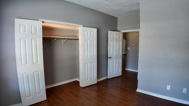 unfurnished bedroom featuring dark hardwood / wood-style flooring and a closet