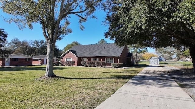 ranch-style home with a front lawn and a storage shed