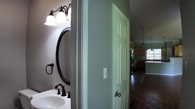 bathroom featuring hardwood / wood-style floors, ornamental molding, and sink