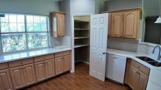 kitchen with sink, dark wood-type flooring, tasteful backsplash, white dishwasher, and decorative light fixtures