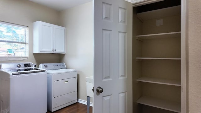 clothes washing area featuring cabinets, separate washer and dryer, and dark wood-type flooring