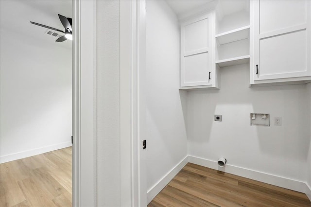 washroom with cabinet space, hookup for an electric dryer, baseboards, and light wood-style floors