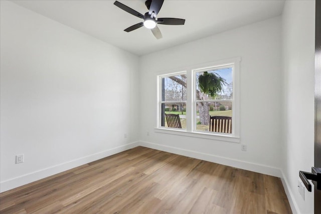 unfurnished room featuring ceiling fan, baseboards, and wood finished floors