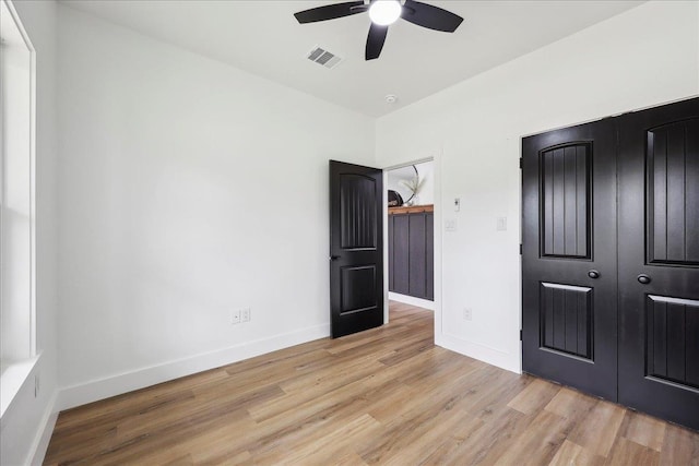 unfurnished bedroom featuring visible vents, light wood-style flooring, a ceiling fan, and baseboards