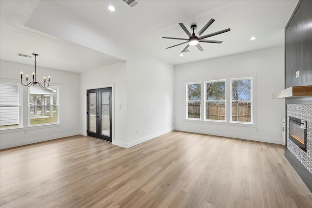 unfurnished living room with baseboards, light wood-style floors, and a tiled fireplace