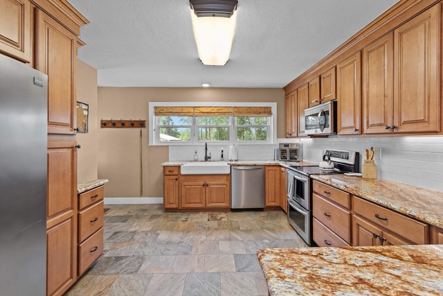 kitchen with sink, backsplash, and appliances with stainless steel finishes