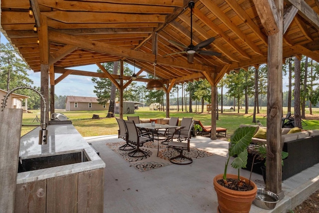 view of patio featuring ceiling fan, a gazebo, and exterior kitchen