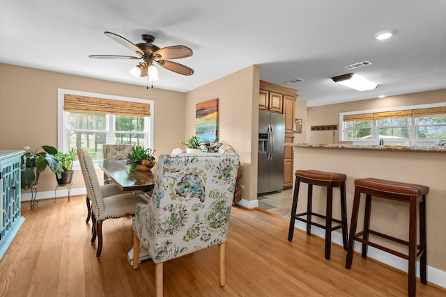 dining room with light hardwood / wood-style flooring and ceiling fan