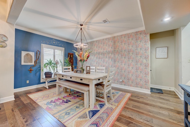 dining area featuring hardwood / wood-style floors, a chandelier, and ornamental molding