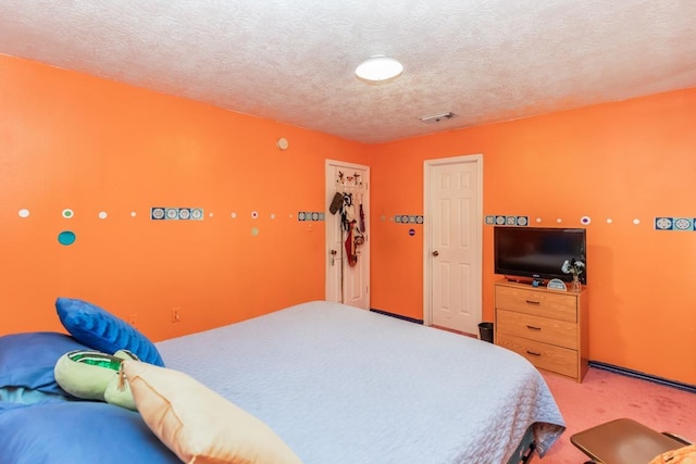 carpeted bedroom featuring a textured ceiling