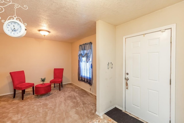 carpeted foyer entrance with a textured ceiling