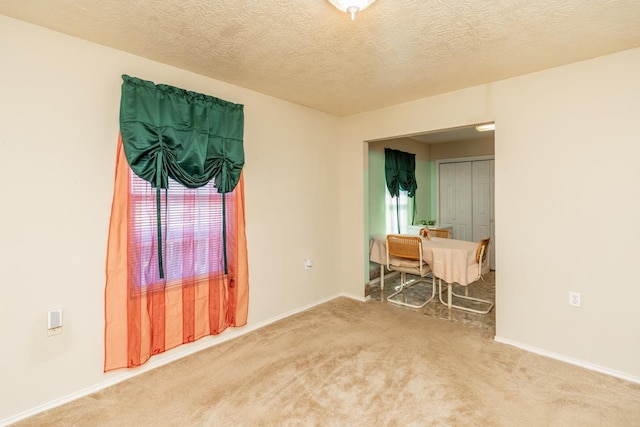 carpeted empty room with a textured ceiling