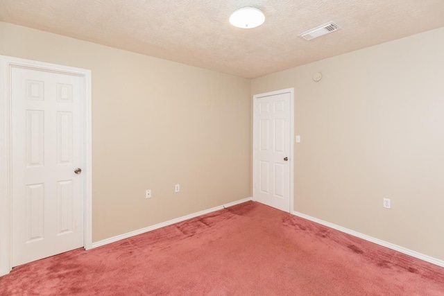 carpeted spare room with a textured ceiling