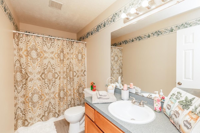 bathroom with vanity, a textured ceiling, and toilet