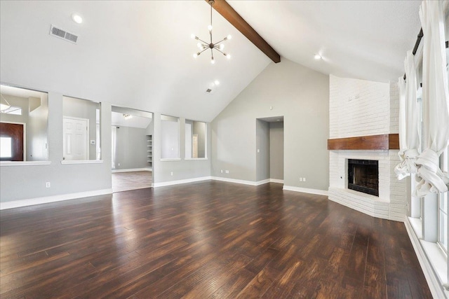 unfurnished living room with a brick fireplace, beam ceiling, dark wood-type flooring, and a chandelier