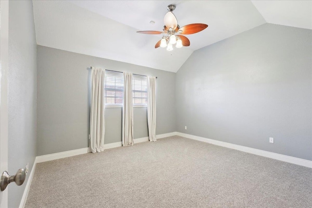 carpeted empty room with vaulted ceiling and ceiling fan