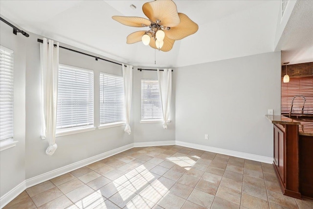 tiled empty room featuring ceiling fan