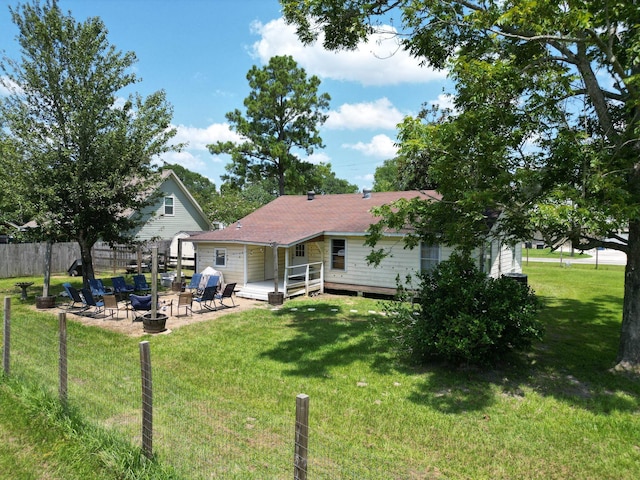 rear view of house featuring a patio, a deck, an outdoor fire pit, and a lawn